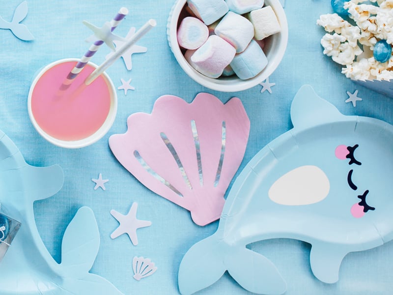 Mise en situation sur table des serviettes en papier forme coquillage rose iridescent