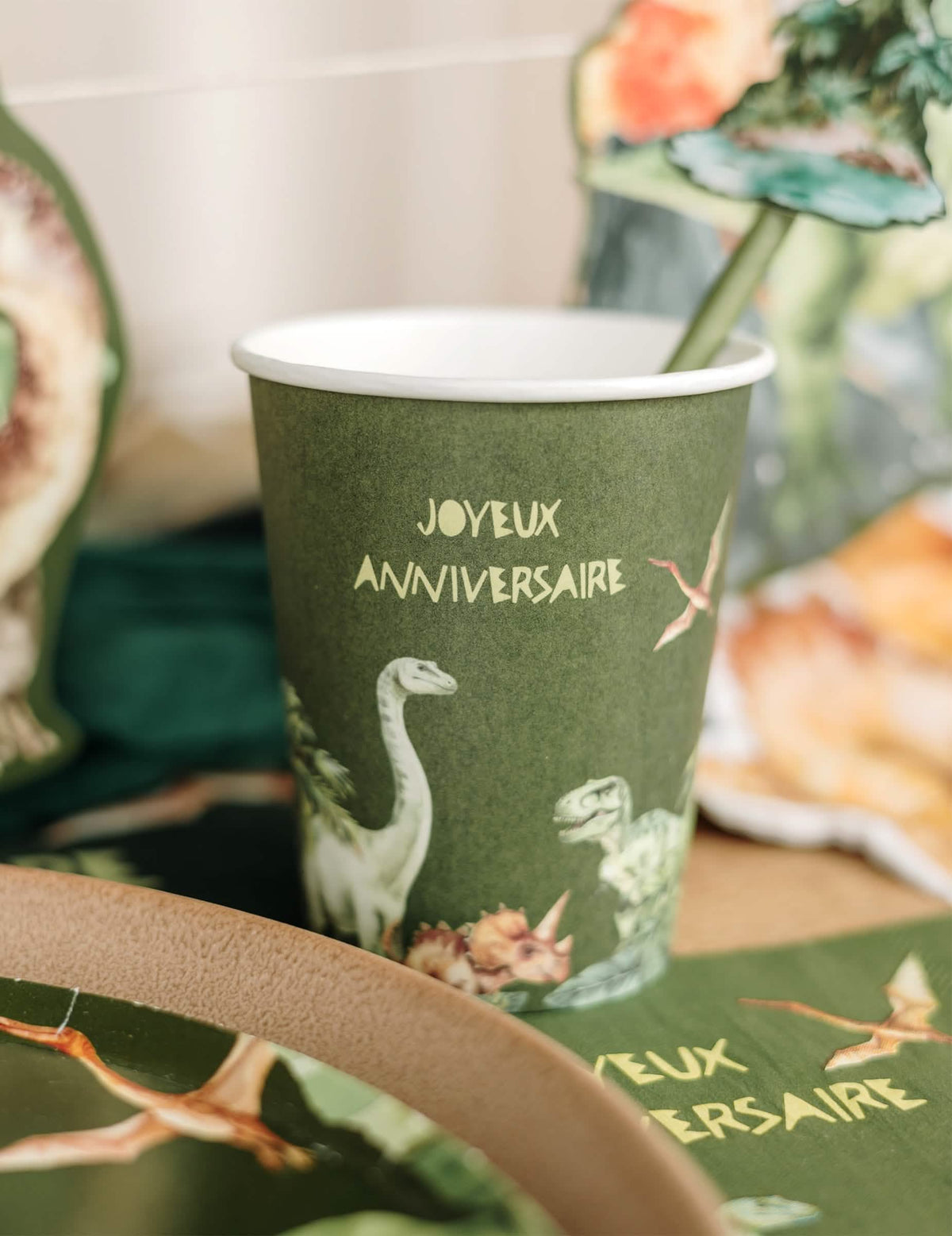 Gros plan sur les illustrations du gobelet joyeux anniversaire dinosaures