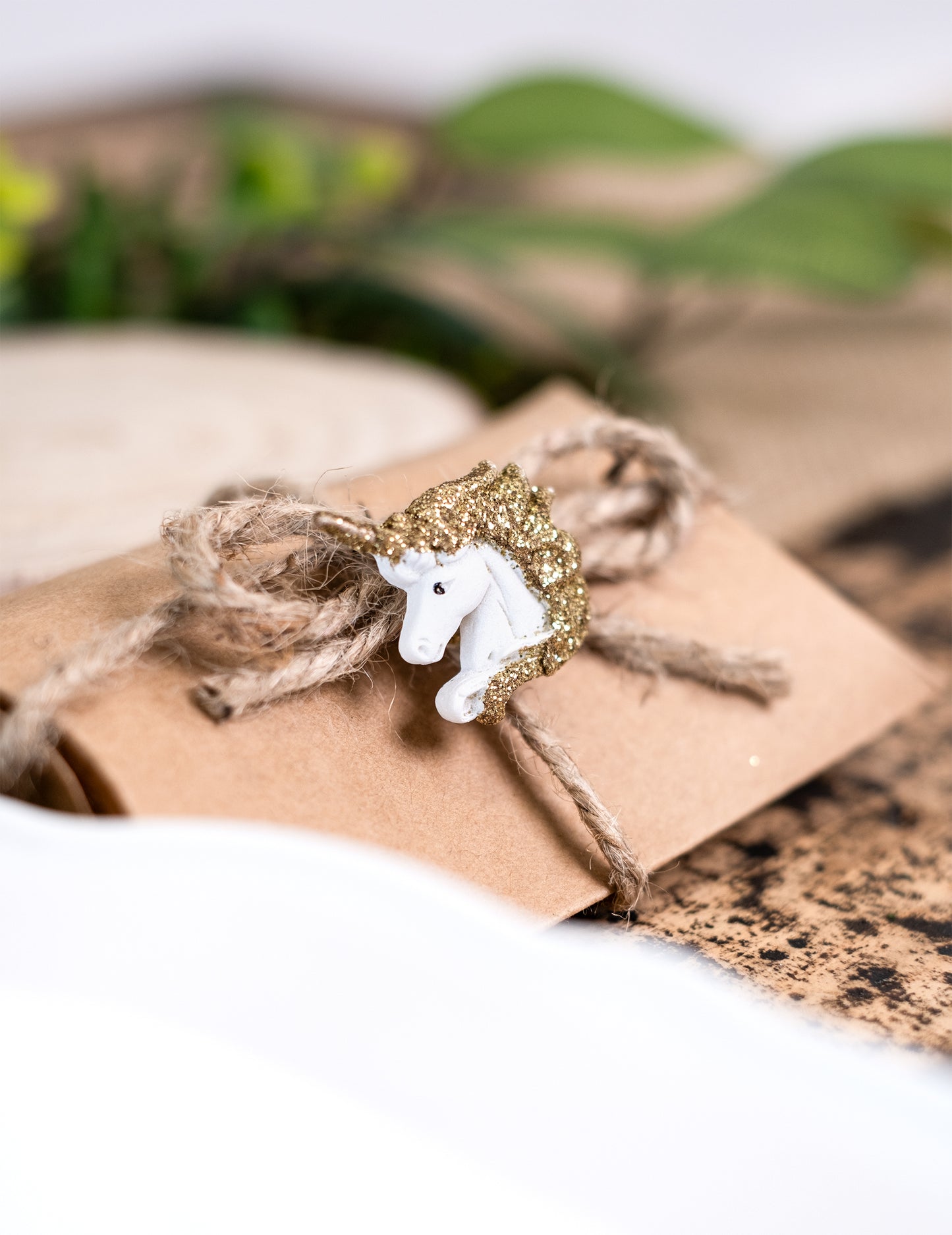 Zoom sur une licorne décorant une pochette des licornes adhésives en résine blanches et paillettes dorées