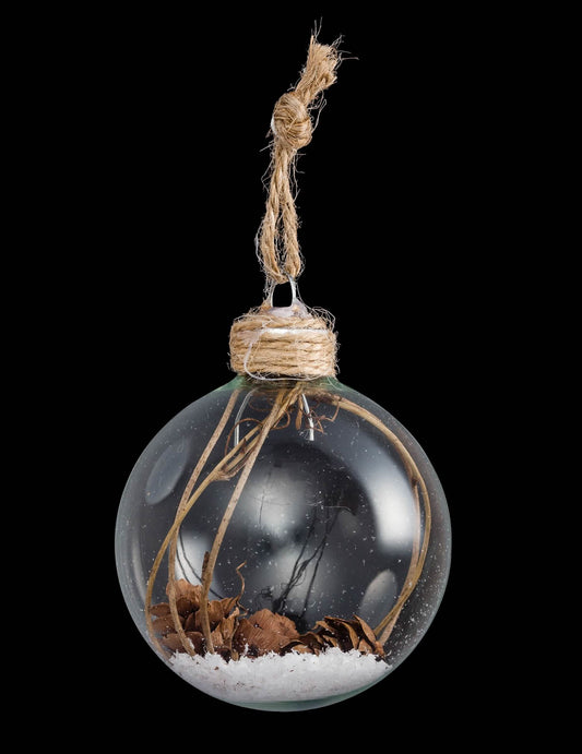Vue de face de la boule de Noël en verre avec pommes de pin et neige