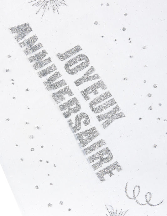 Gros plan sur l'inscription du chemin de table organza Joyeux anniversaire argent pailleté