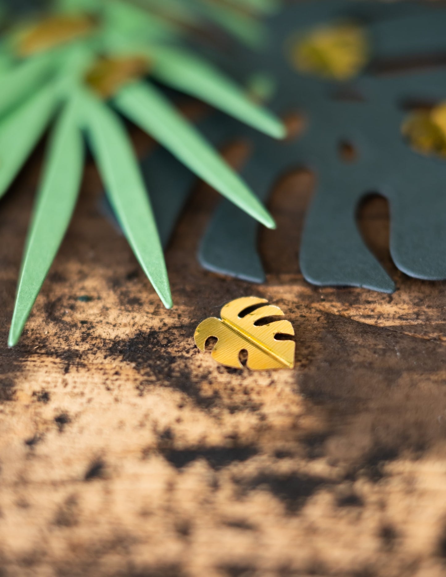 Gros plan d'une feuille dorée de monstera du confettis de table feuilles tropicales