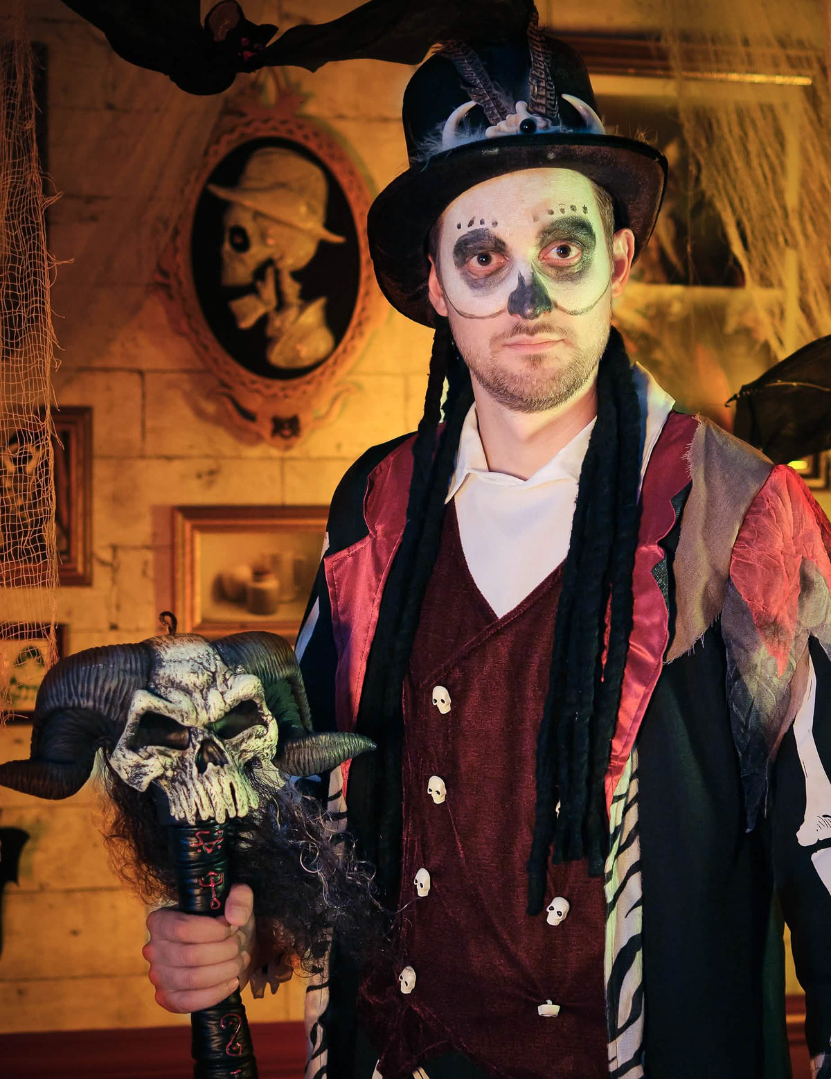 Lähikuva meikeistä ja voodoo-noidan valtikasta miesten asuun