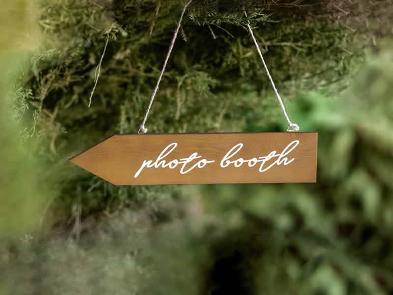 Puinen photobooth-suuntakyltin ripustettu lavastus
