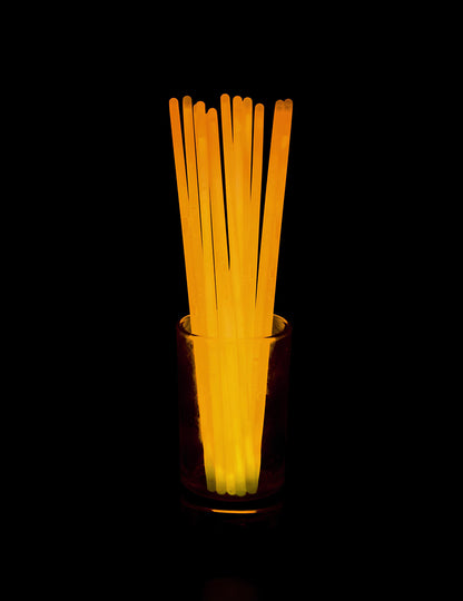 Rendu lumineux dans l'obscurité du lot de 100 bracelets phosphorescents pour fête orange