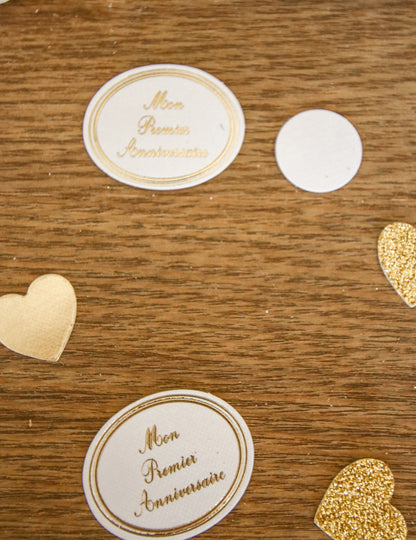 Détail des médaillons et des cœurs des confettis mon premier anniversaire