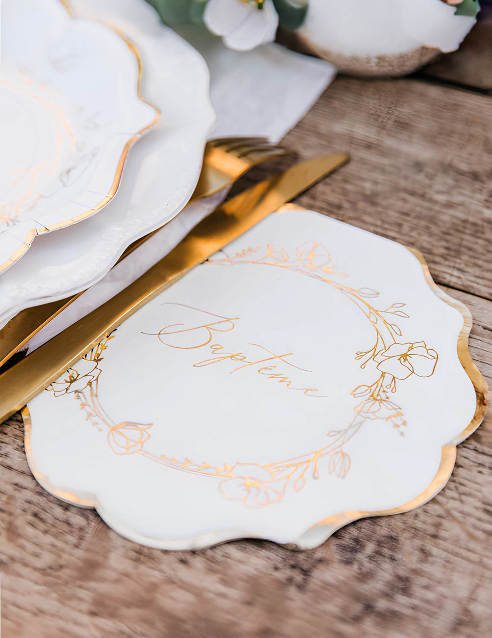 Gros plan sur les motifs dorés des serviettes en papier baptême