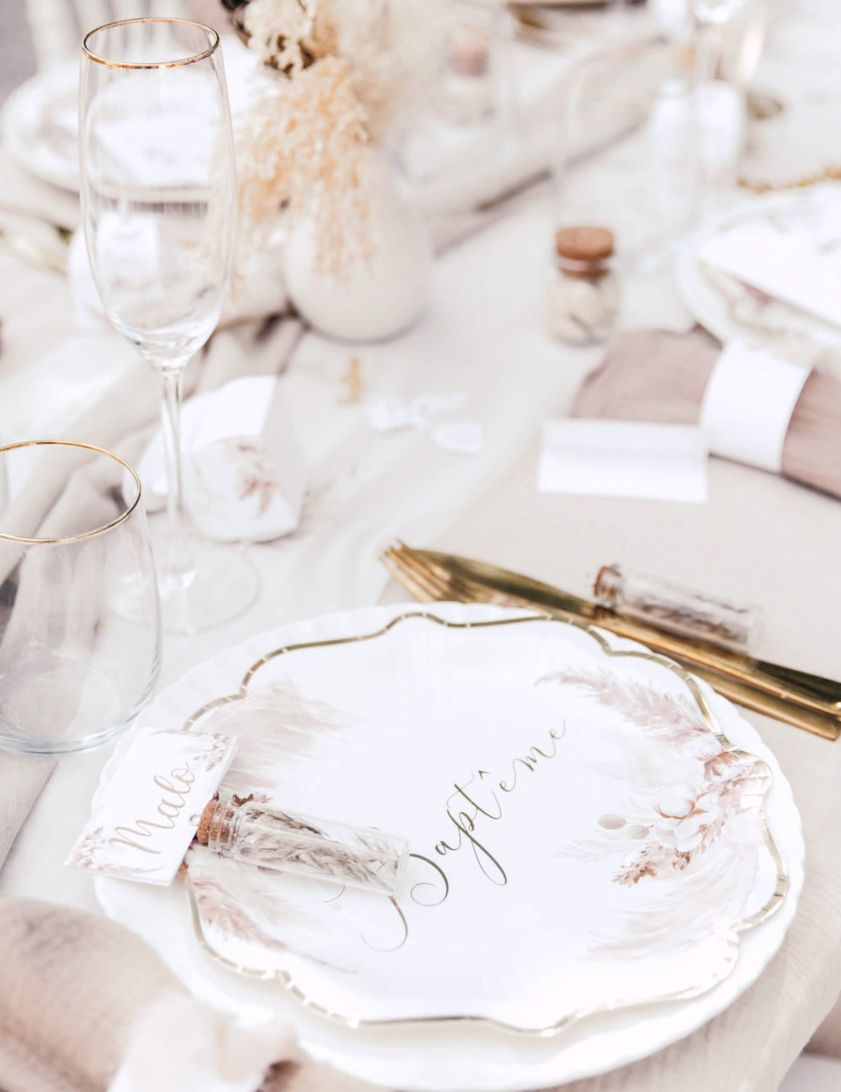 Mise en ambiance de la décoration de table des serviettes en papier pampas et fleurs de coton pour baptême dorées