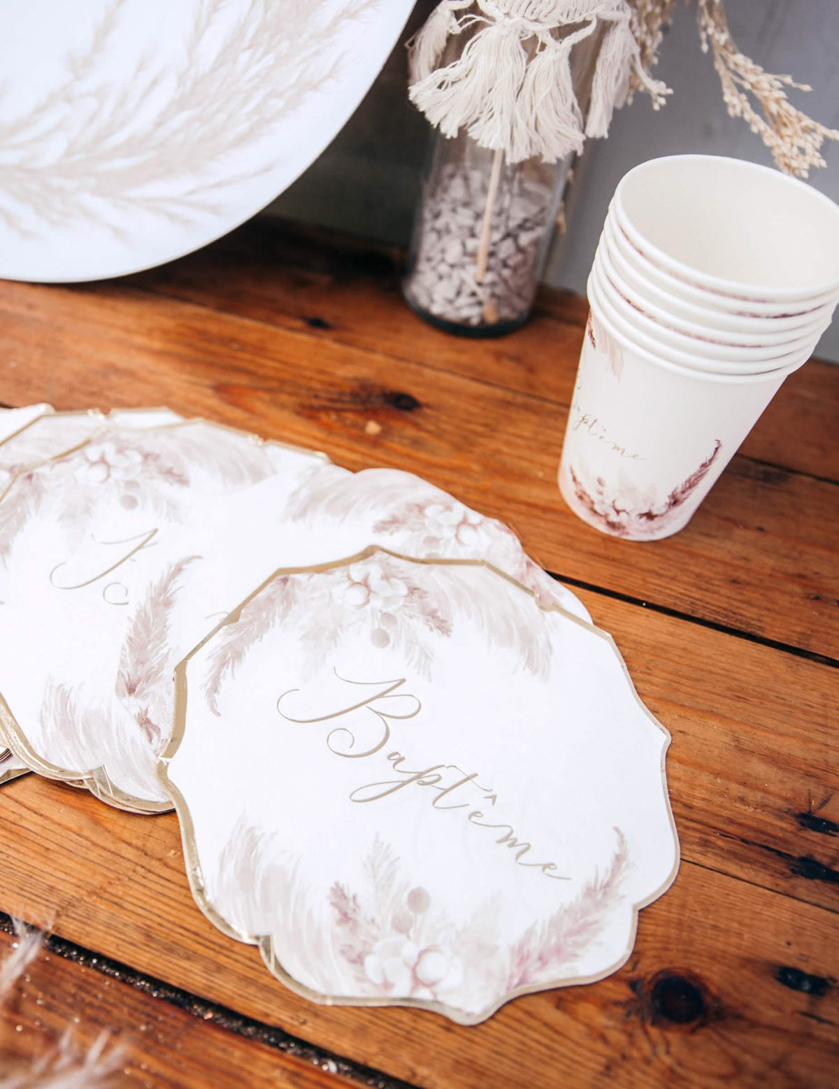 Zoom sur le motif des serviettes en papier pampas et fleurs de coton pour baptême dorées