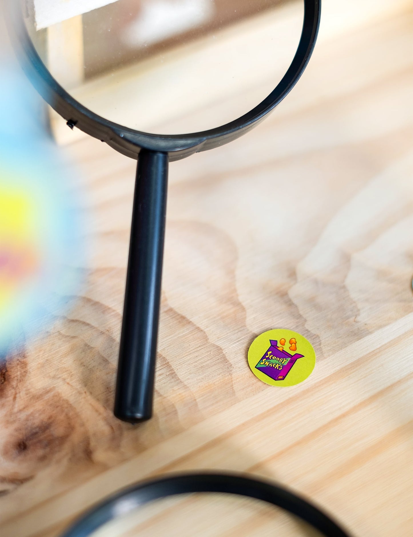 Loupe montrant le détail d'un motif des confettis Scooby-Doo