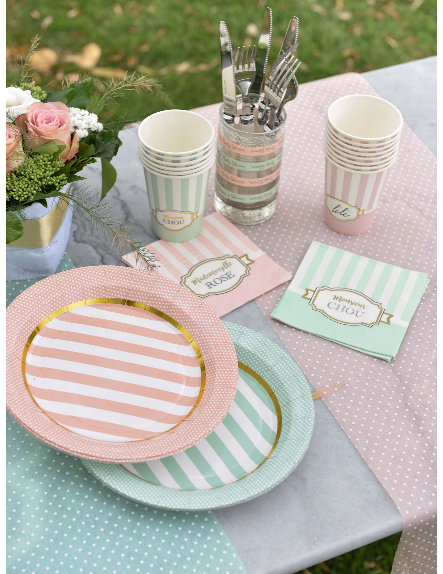 Mise en situation sur une table des serviettes en papier Mademoiselle rose pour baby shower rose à rayures blanches