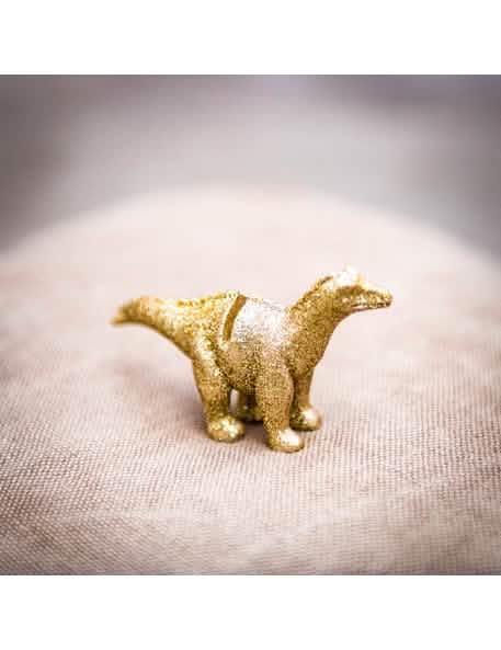 Lähikuva dinosaurus-hartsisen paikkamerkin kultaisista kimalteista