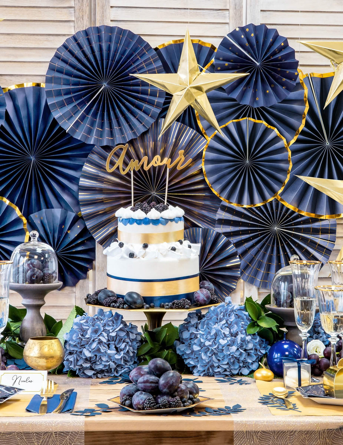 Mise en scène sur un buffet des 4 rosaces décoratives en papier pour fête marine et dorées