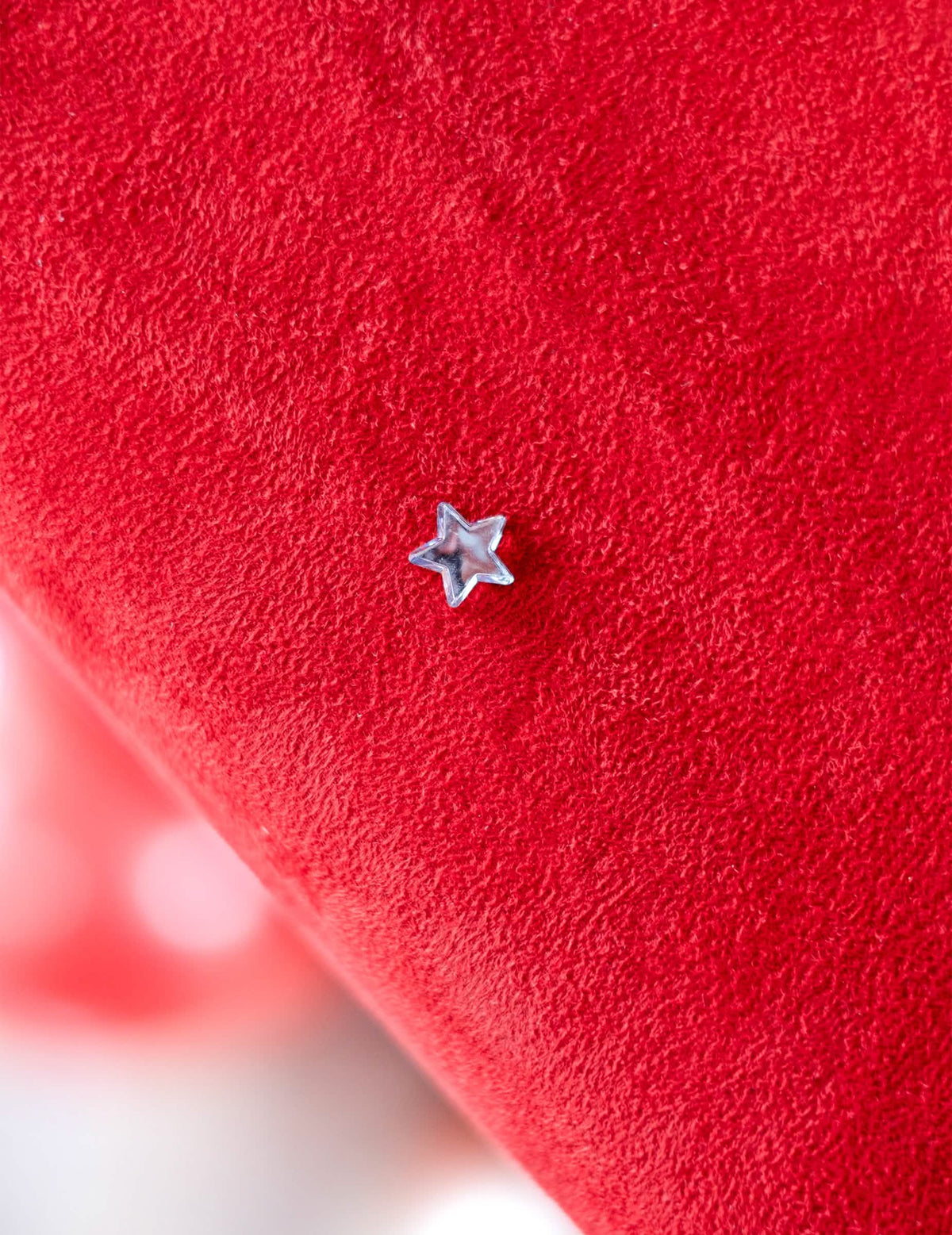 Gros plan d'une étoile sur fond rouge du confettis de table étoiles miroir pour fête
