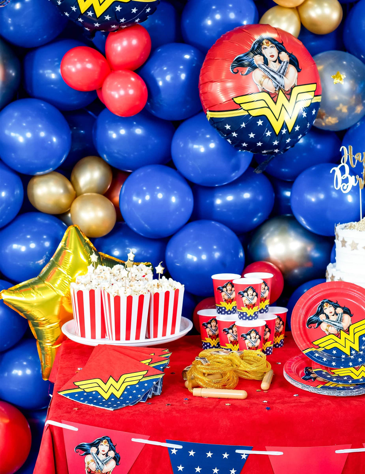 Punaiset ja valkoiset raidalliset pahviset popcorn- laatikot juhlapöytäasetelmaan
