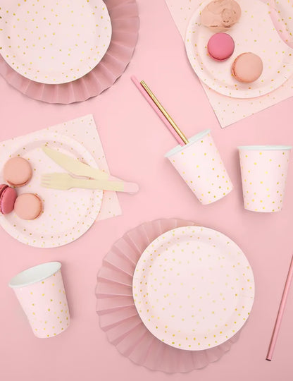 Mise en situation festive des gobelets en carton rose pâle et pois dorés