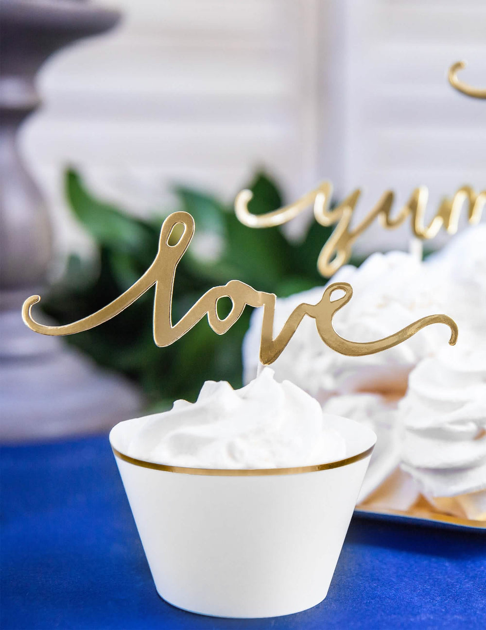 Gros plan sur le cake topper love doré des habillages à cupcakes en papier pour mariage