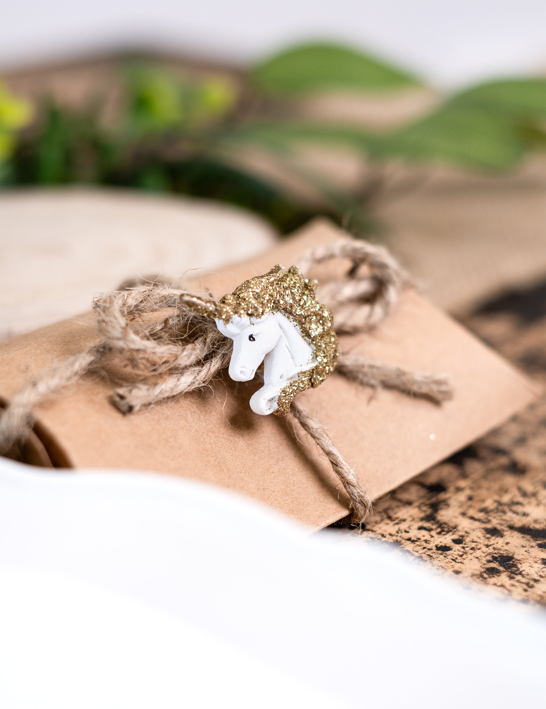 Zoom sur une licorne décorant une pochette des licornes adhésives en résine blanches et paillettes dorées