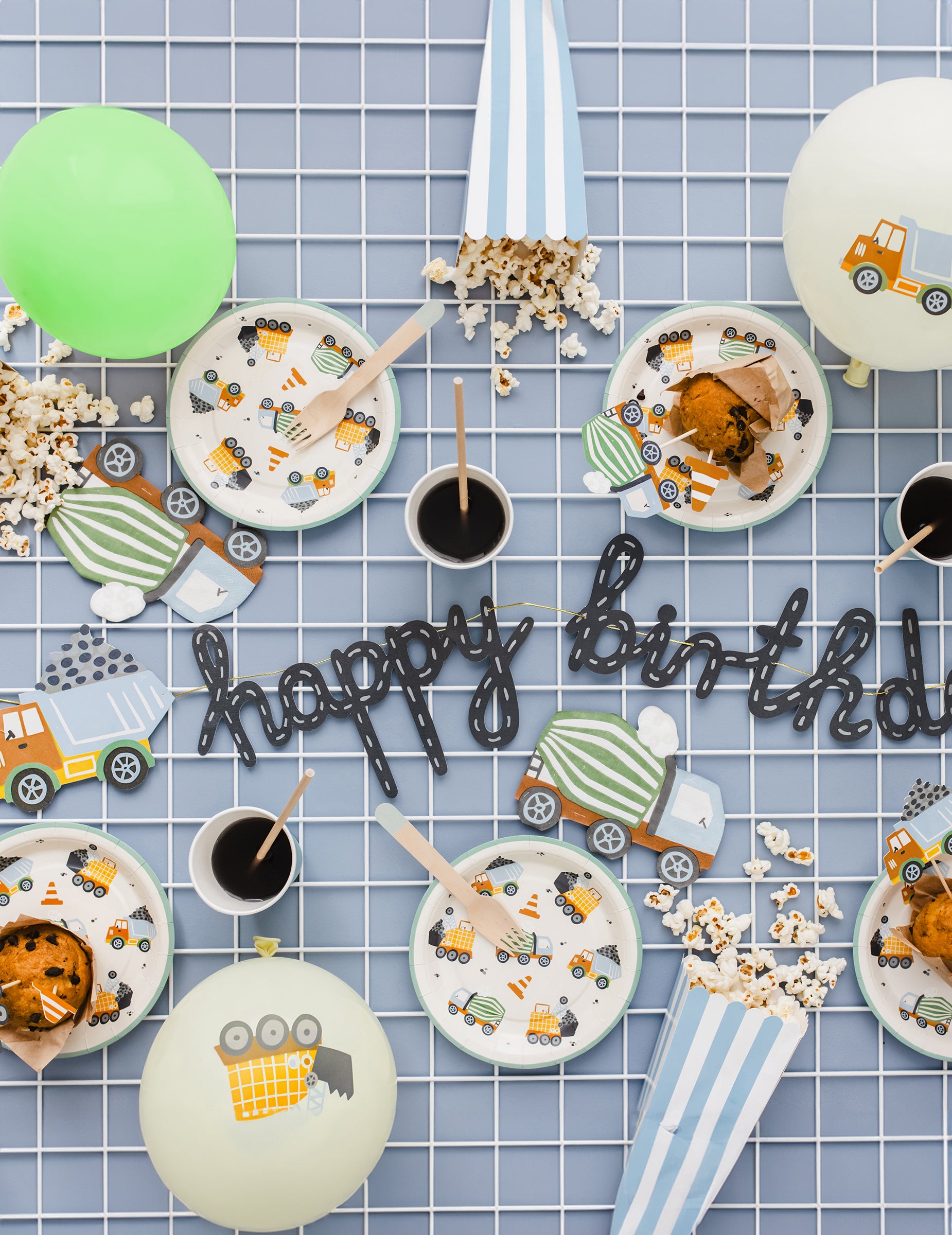 Mise en scène avec ballons et guirlande des assiettes camions de chantier