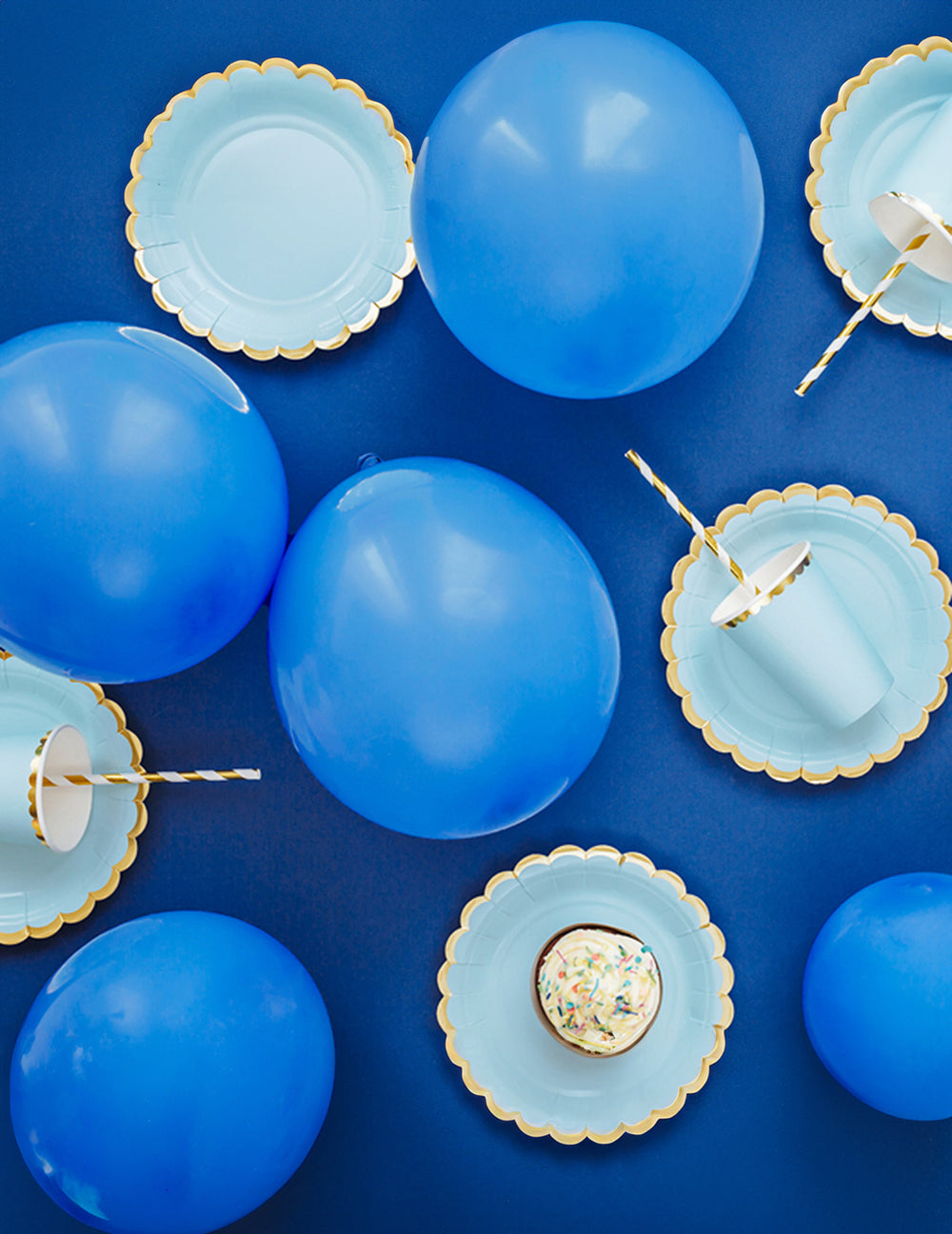 Vue de dessus de la décoration de fête avec les assiettes en carton bleu ciel et dorure dentelée