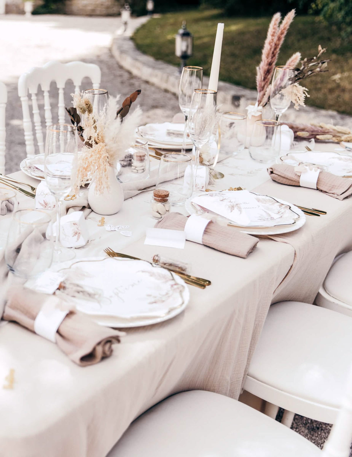 Vue d'ensemble de la table avec les assiettes baptême pampas et fleurs de coton