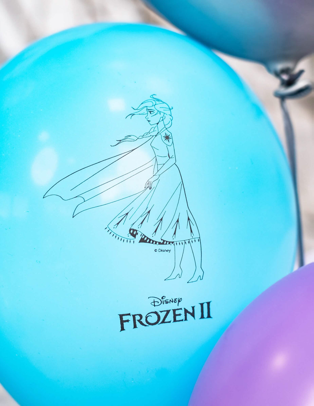 Lähikuva Elsan kuvituksesta ja Frozen 2 -lateksiilmapallojen logo