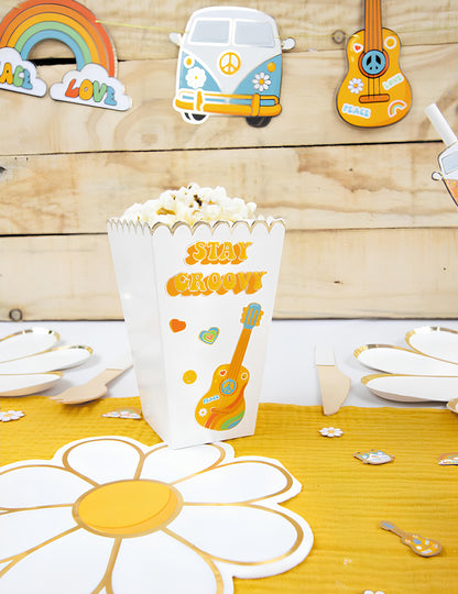 Mise en scène sur table de fête des boîtes à pop corn festonnées pour fête blanc et or