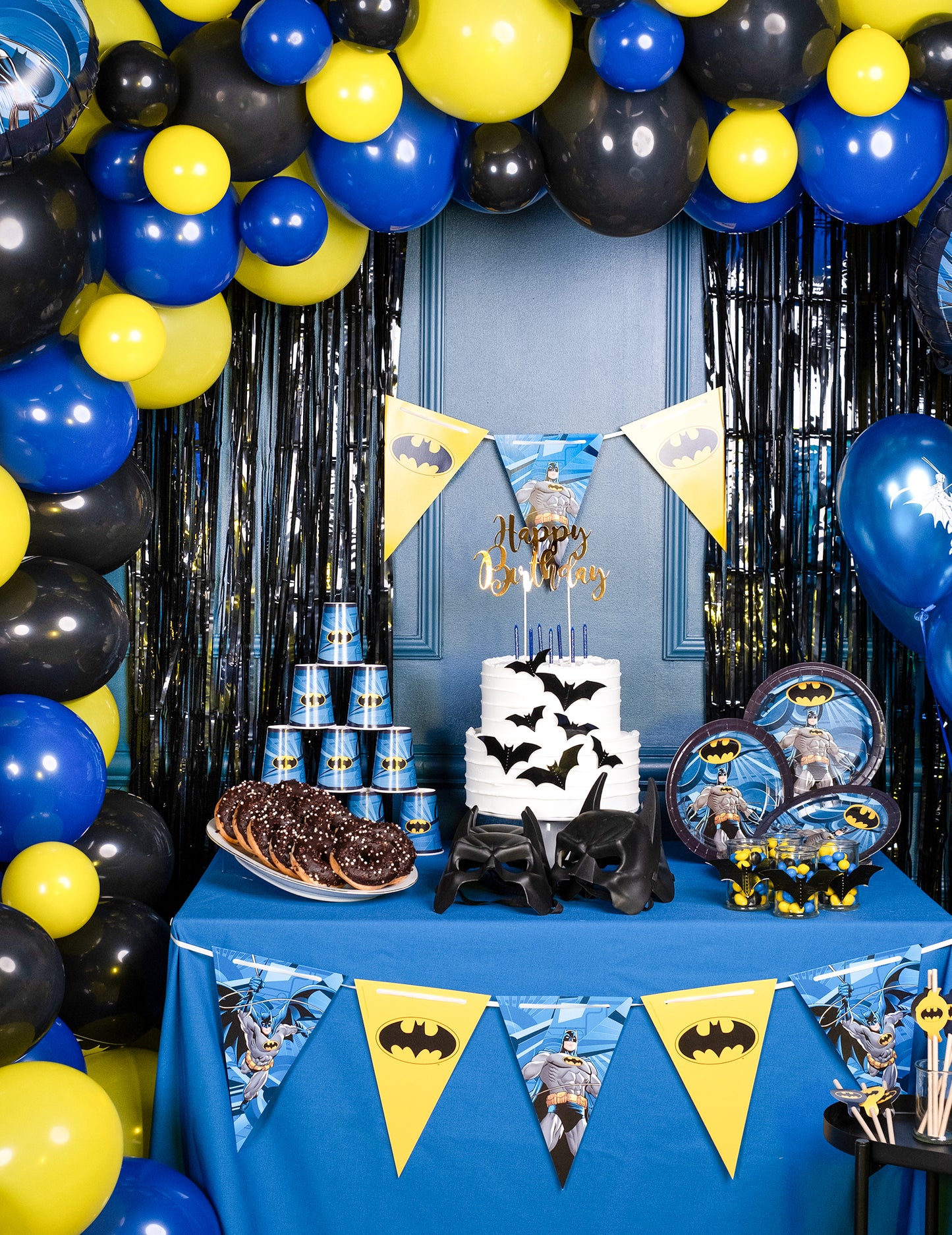 Mise en scène sur une table d'anniversaire des gobelets en carton Batman
