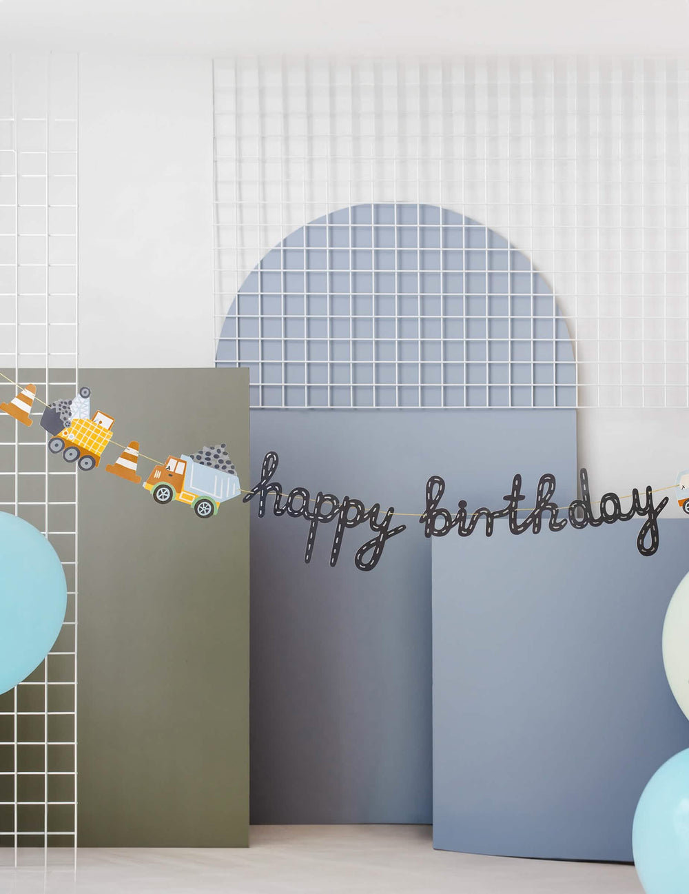Gros plan sur l'inscription et les engins de la bannière Happy Birthday camions de chantier
