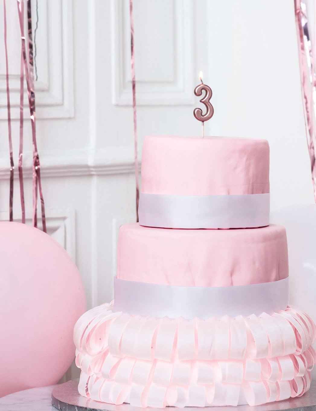Mise en situation sur un gâteau de la bougie d'anniversaire chiffre 3 rose gold métallisée avec pic