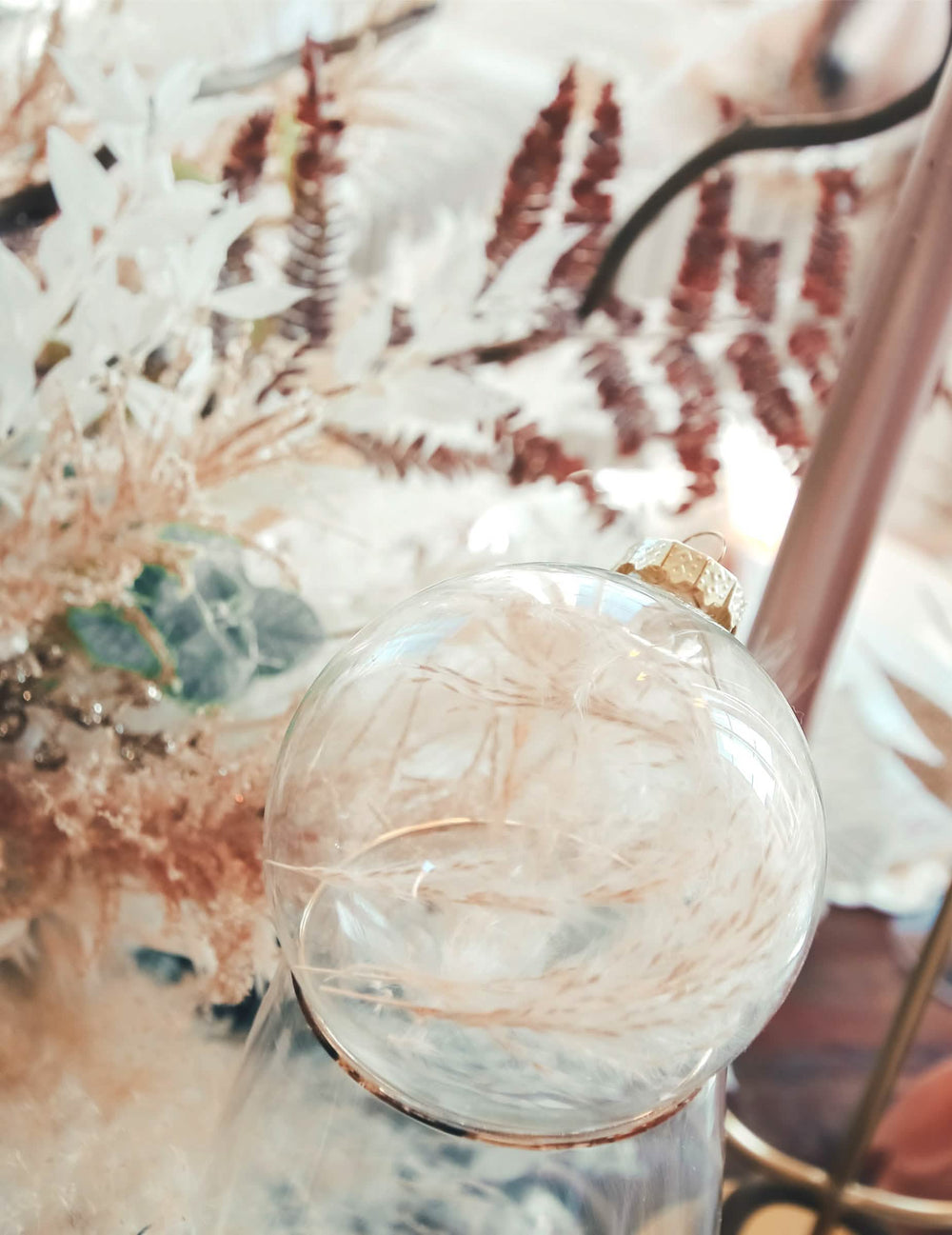 Détail des plumes à l'intérieur de la boule de noël personnalisable pour décoration transparente à suspendre