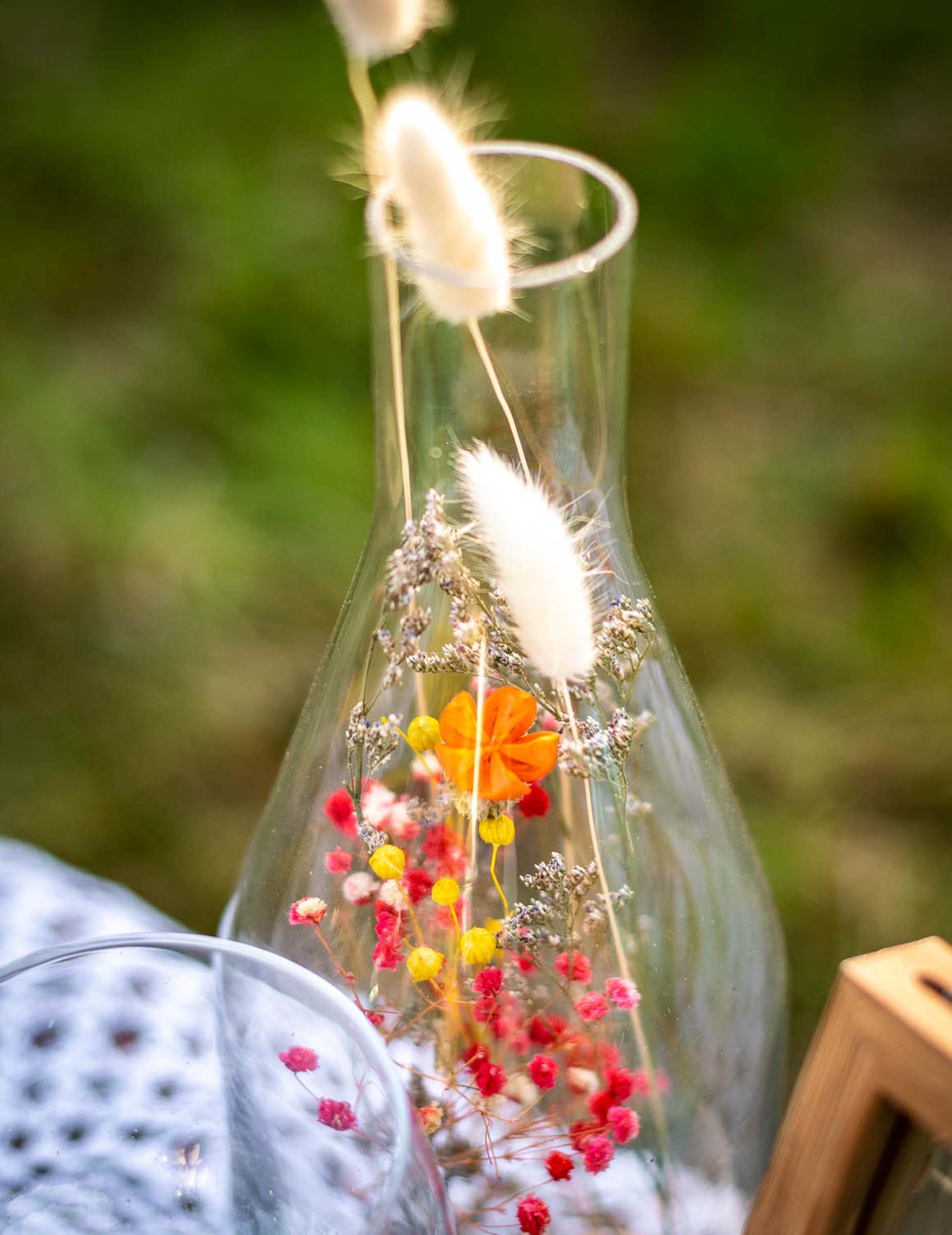 Gros plan sur le goulot de la bouteille avec fleurs séchées pour centre de table colorées