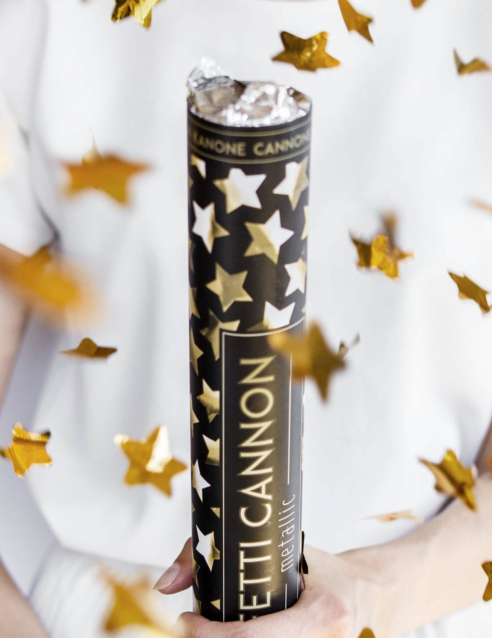 Mise en situation avec confettis en vol du canon à confettis étoiles métallisées dorées