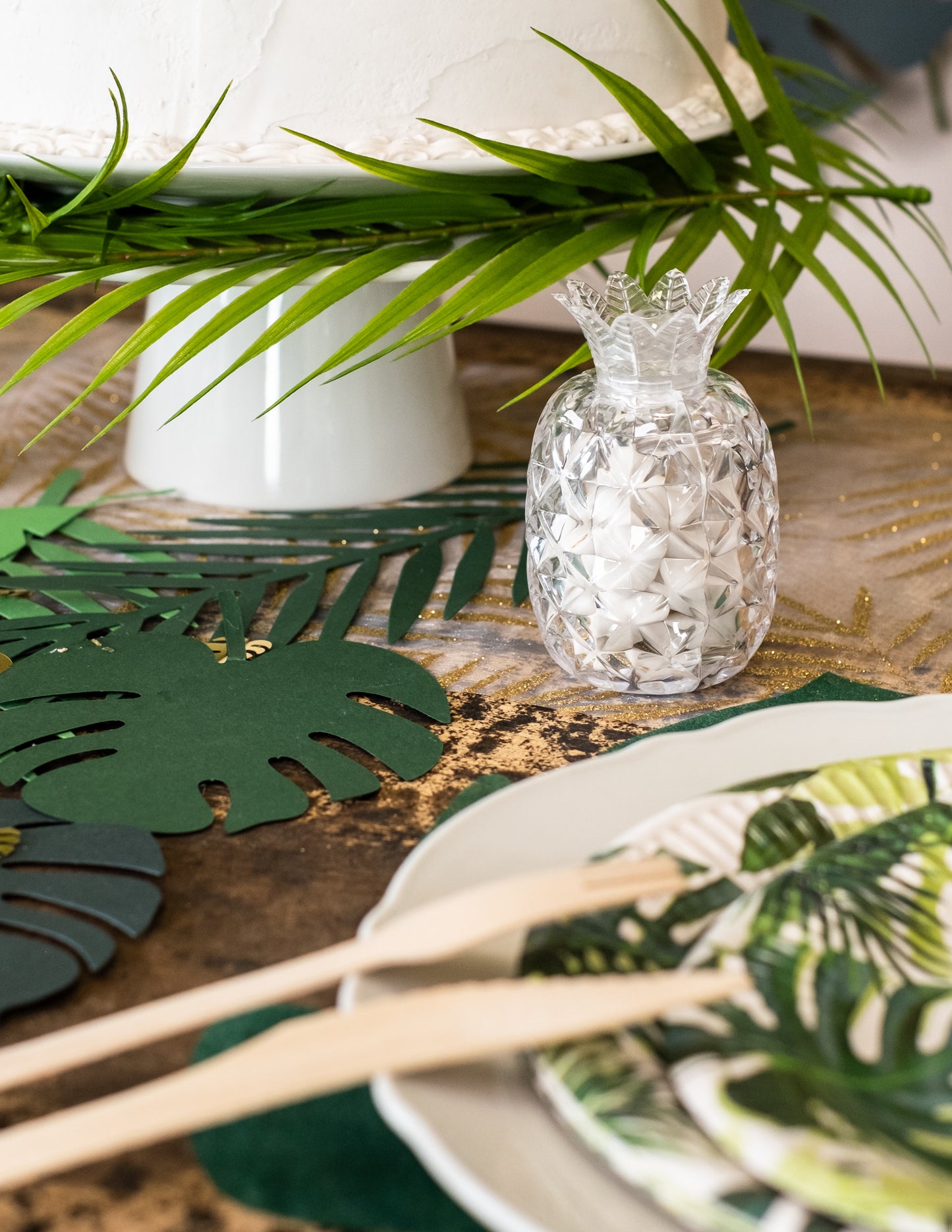Mise en situation du contenant à dragées en forme d'ananas sur une table tropicale