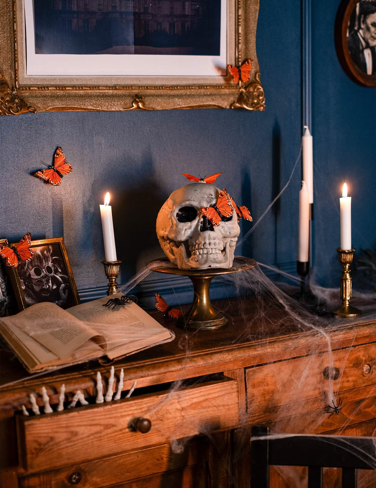 Lavastus perhosilla ja kynttilöillä Halloween-kallokoristeesta