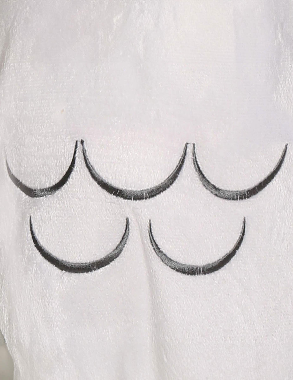 Gros plan sur les motifs de plumes du déguisement chouette magique pour bébé