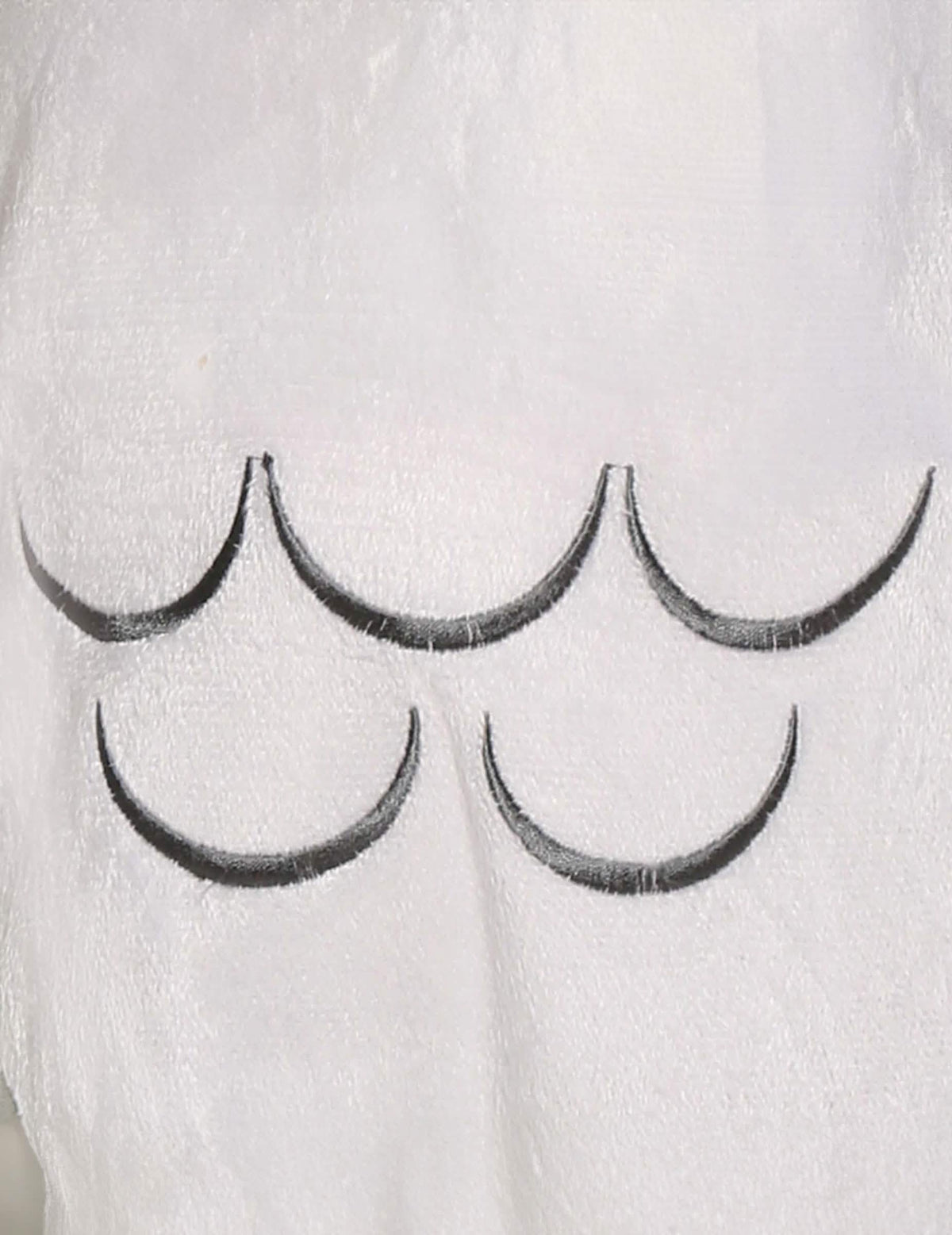 Gros plan sur les motifs de plumes du déguisement chouette magique pour bébé