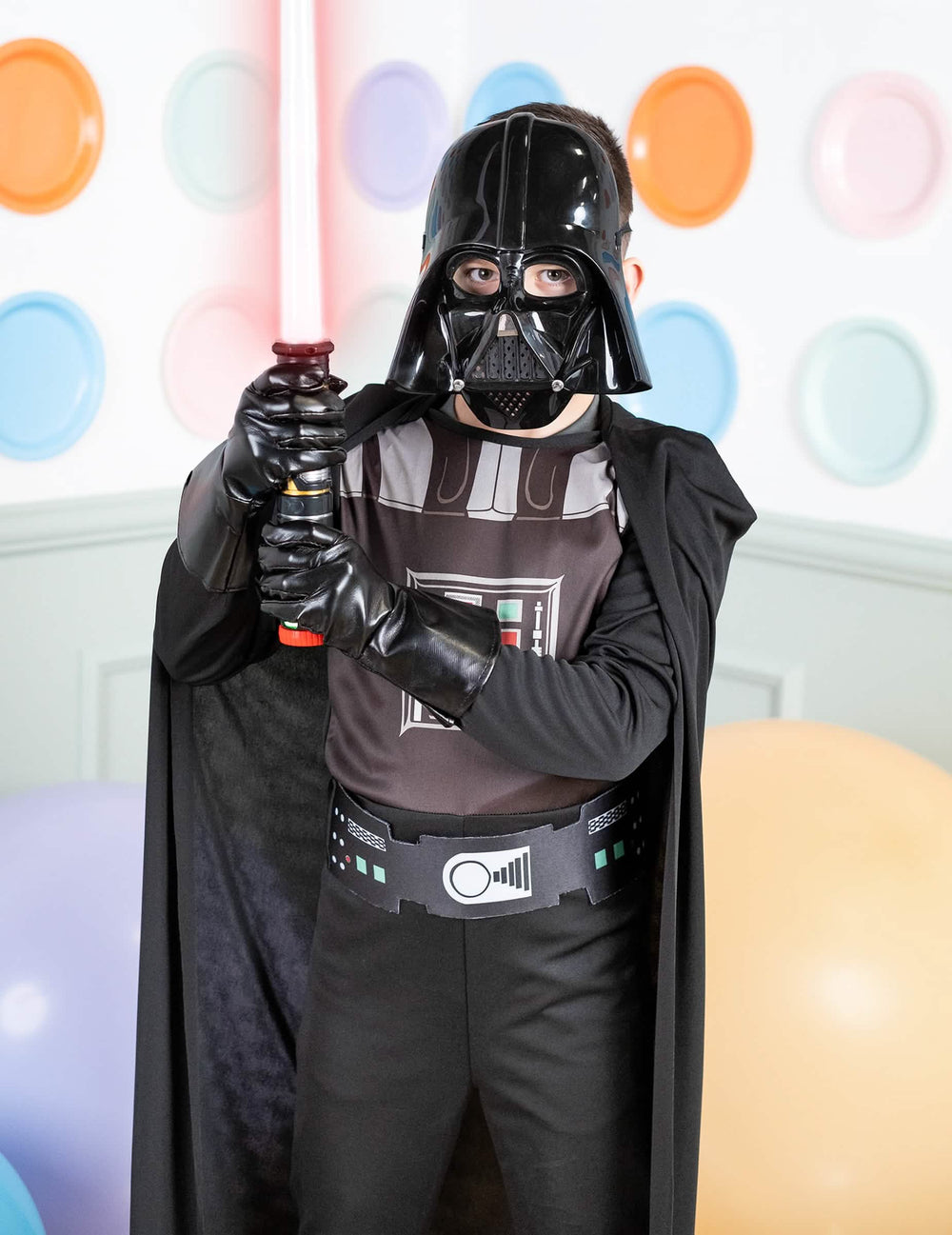 Lähikuva klassisen Darth Vader -pojat-asun rintakehästä ja valomiekasta