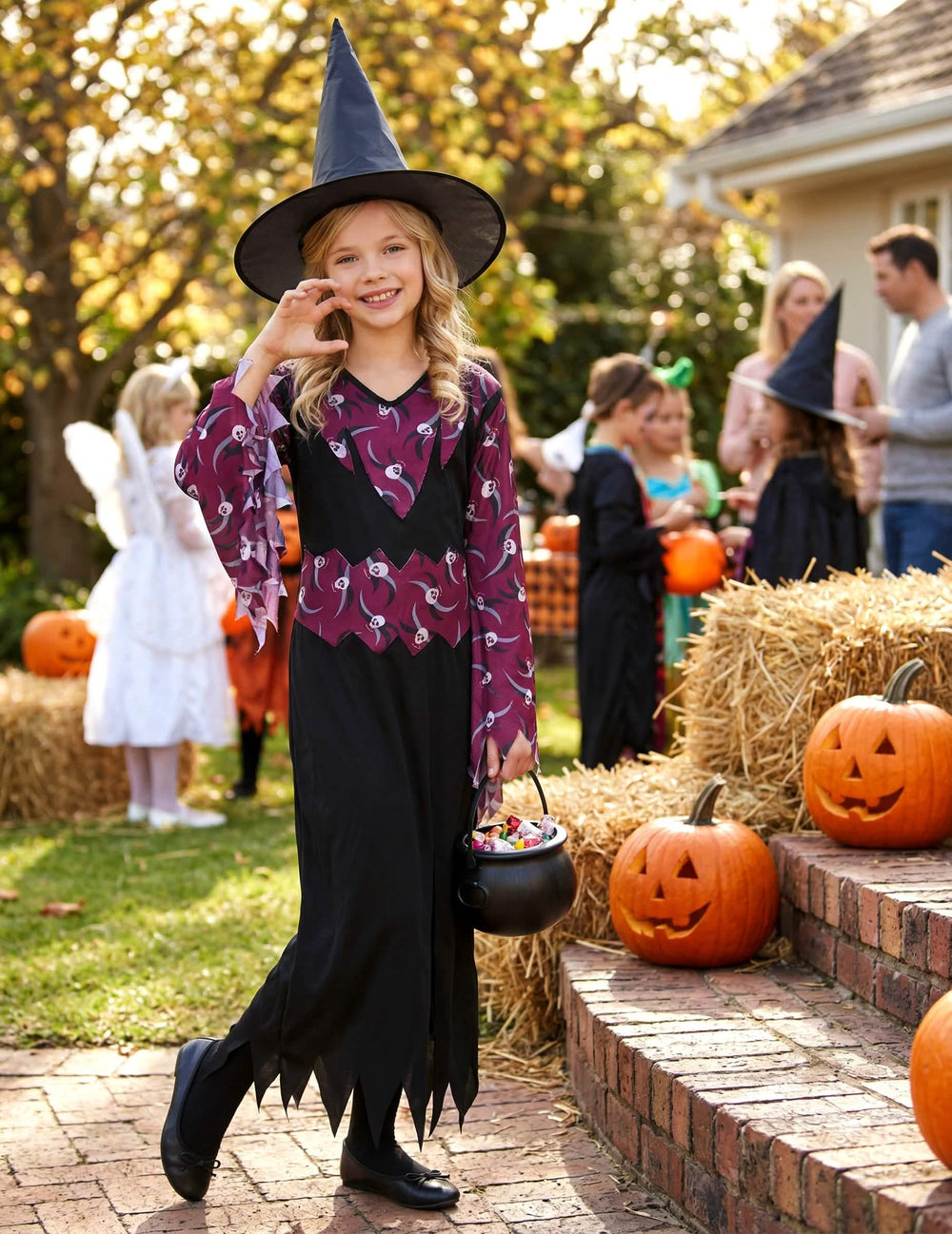 halloween-tilanteessa noita-asuun kuuluvan hatun kanssa tytöt