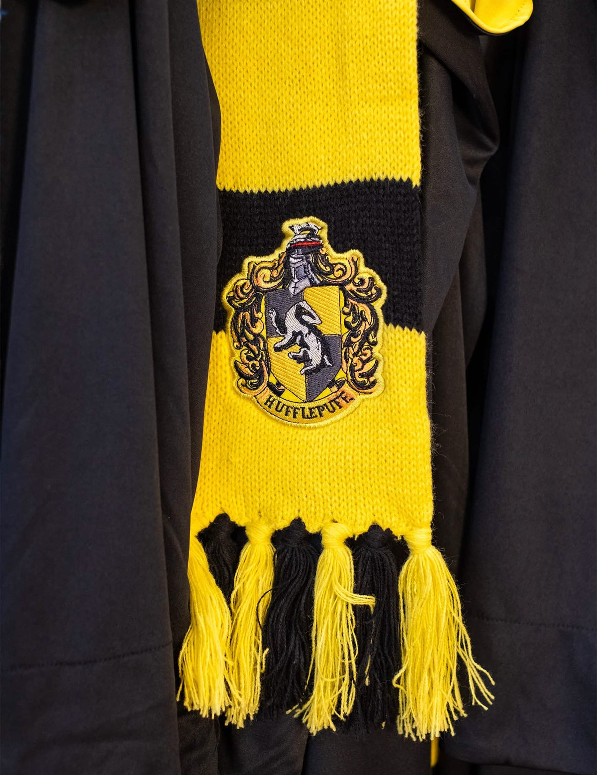 Lähikuva Hufflepuff-luksus-kaulahuivin brodeeratusta vaakunasta
