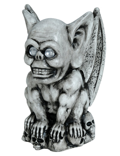 Gargouille décorative pour Halloween grise effet pierre avec yeux clairs sur socle de crânes