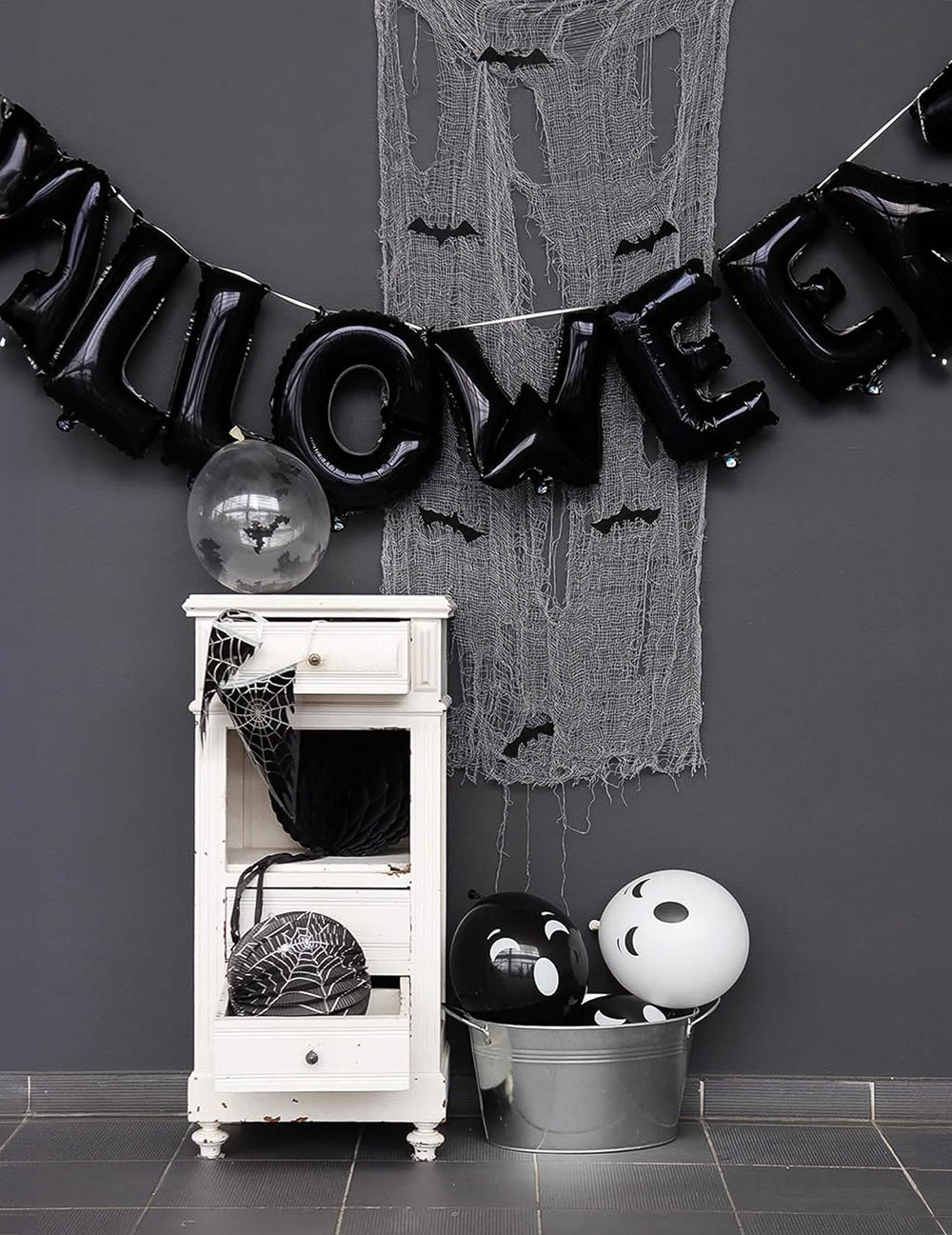 Halloween-lipukkeilla varustetun ilmapalloköynnöksen esittely kuvan muodossa mustilla kirjaimilla