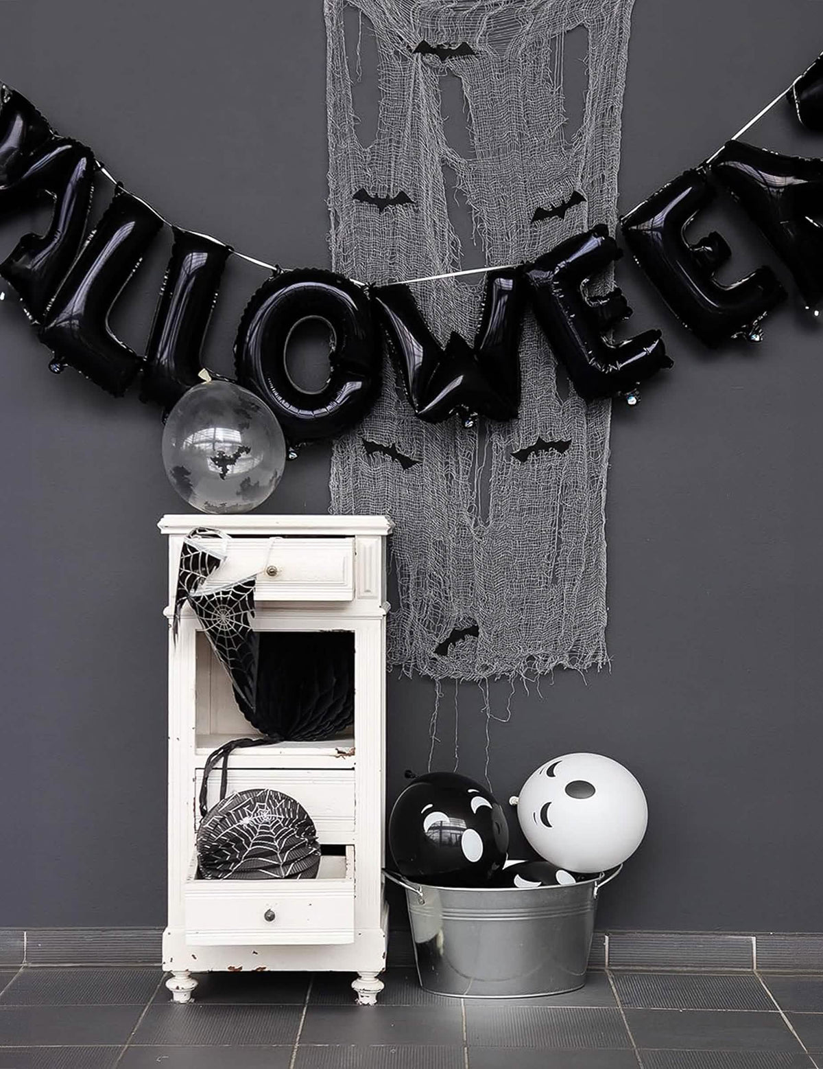 Halloween-lipukkeilla varustetun ilmapalloköynnöksen esittely kuvan muodossa mustilla kirjaimilla