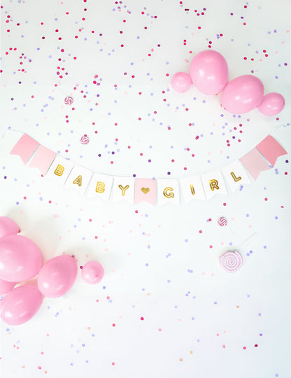 Mise en situation avec ballons et confettis de la guirlande en carton baby girl pour baby shower