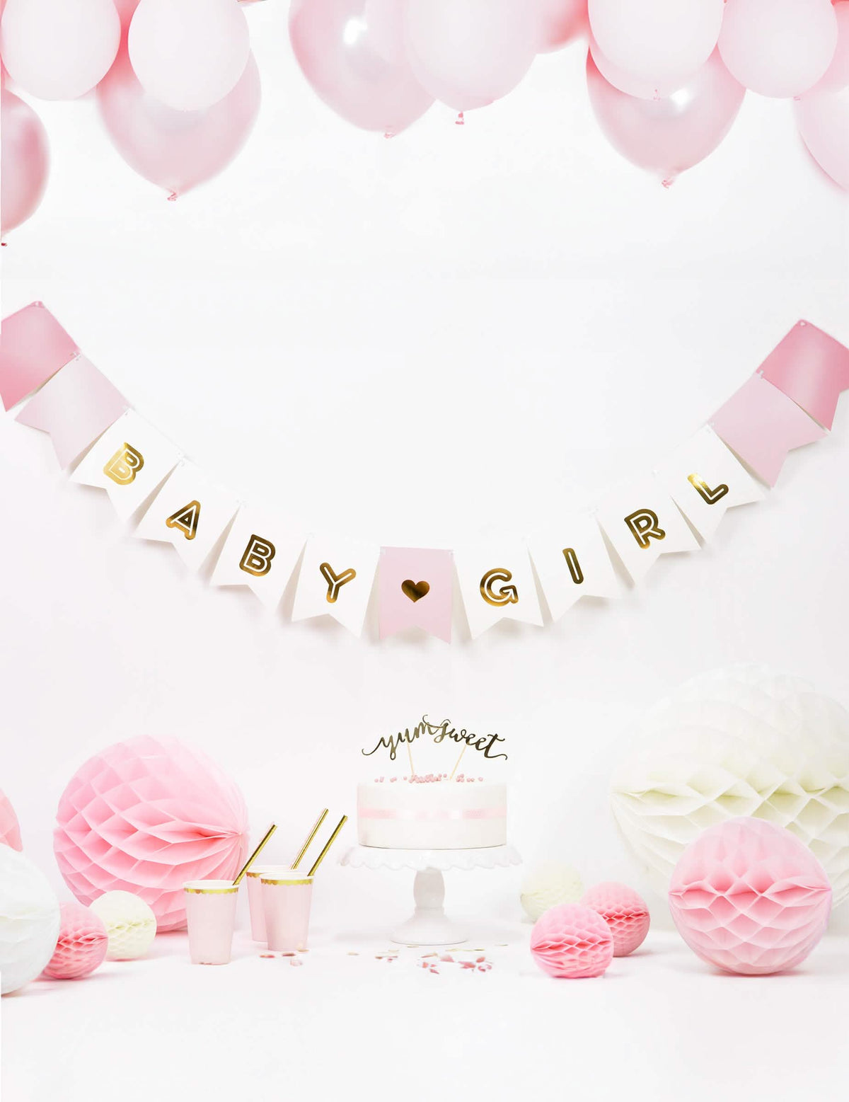 Mise en scène festive avec gâteau et ballons de la guirlande en carton baby girl pour baby shower