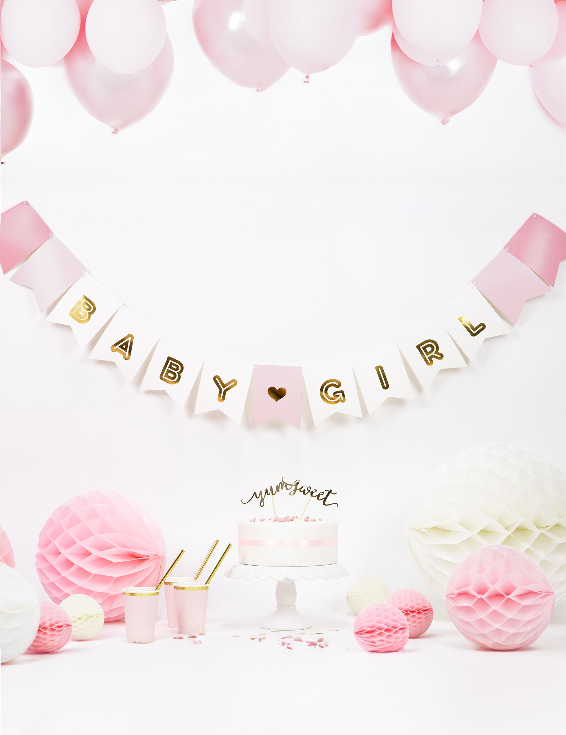 Mise en scène festive avec gâteau et ballons de la guirlande en carton baby girl pour baby shower