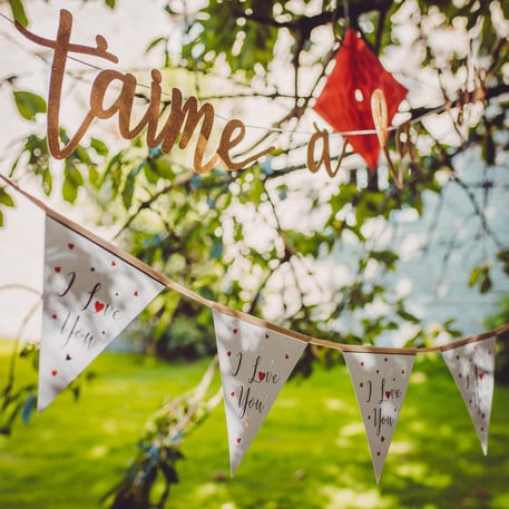 Mise en situation dans un jardin de la guirlande fanions i love you