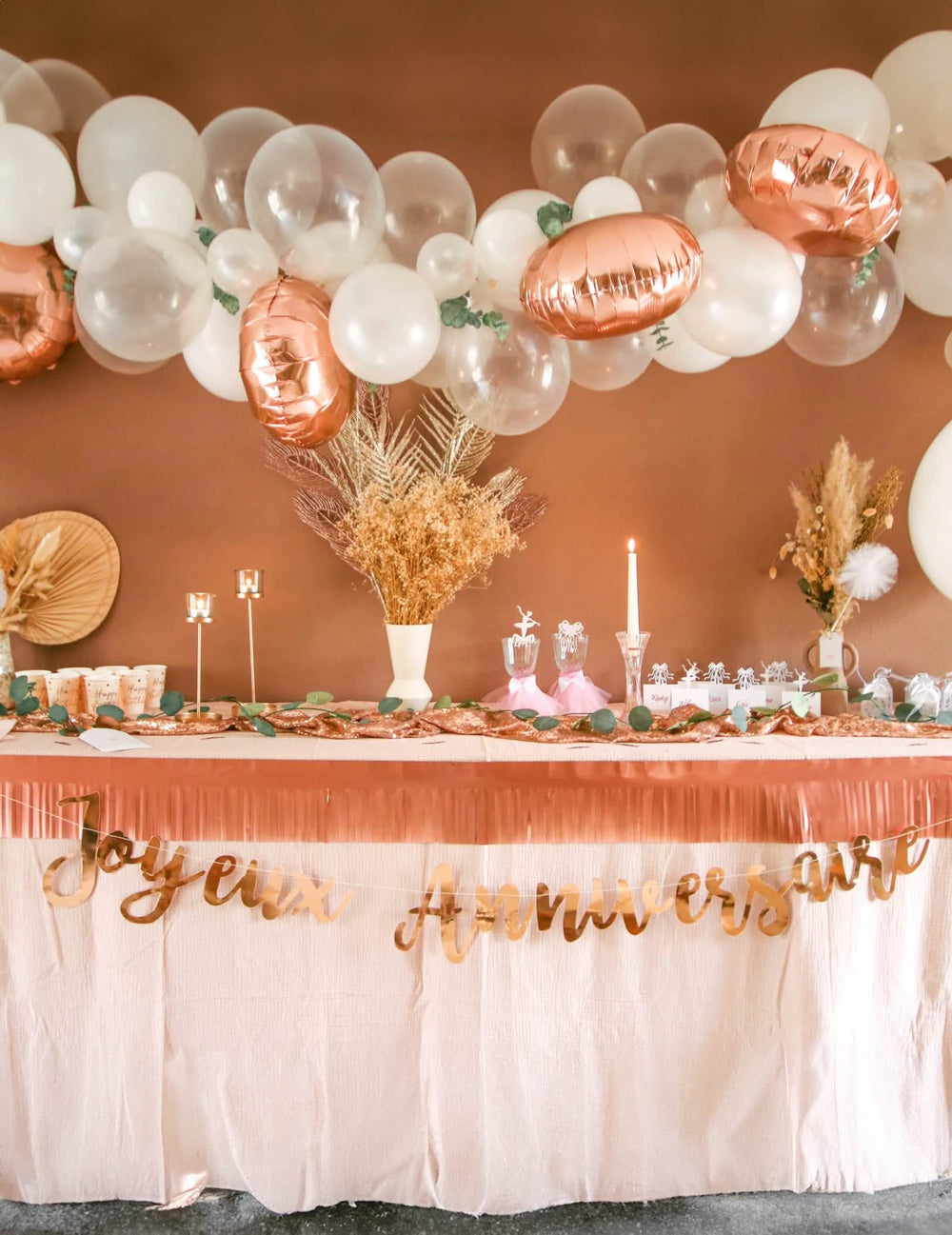 Mise en situation sur une table de fête de la guirlande Joyeux Anniversaire pour fête rose gold
