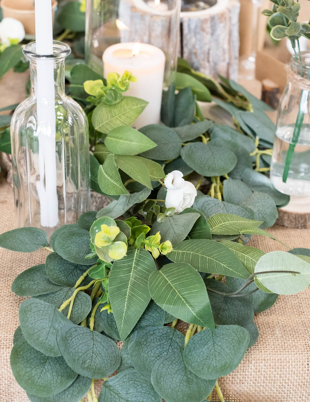 Gros plan sur le feuillage et les fleurs de la guirlande de pivoines, laurier et eucalyptus pour mariage blanche