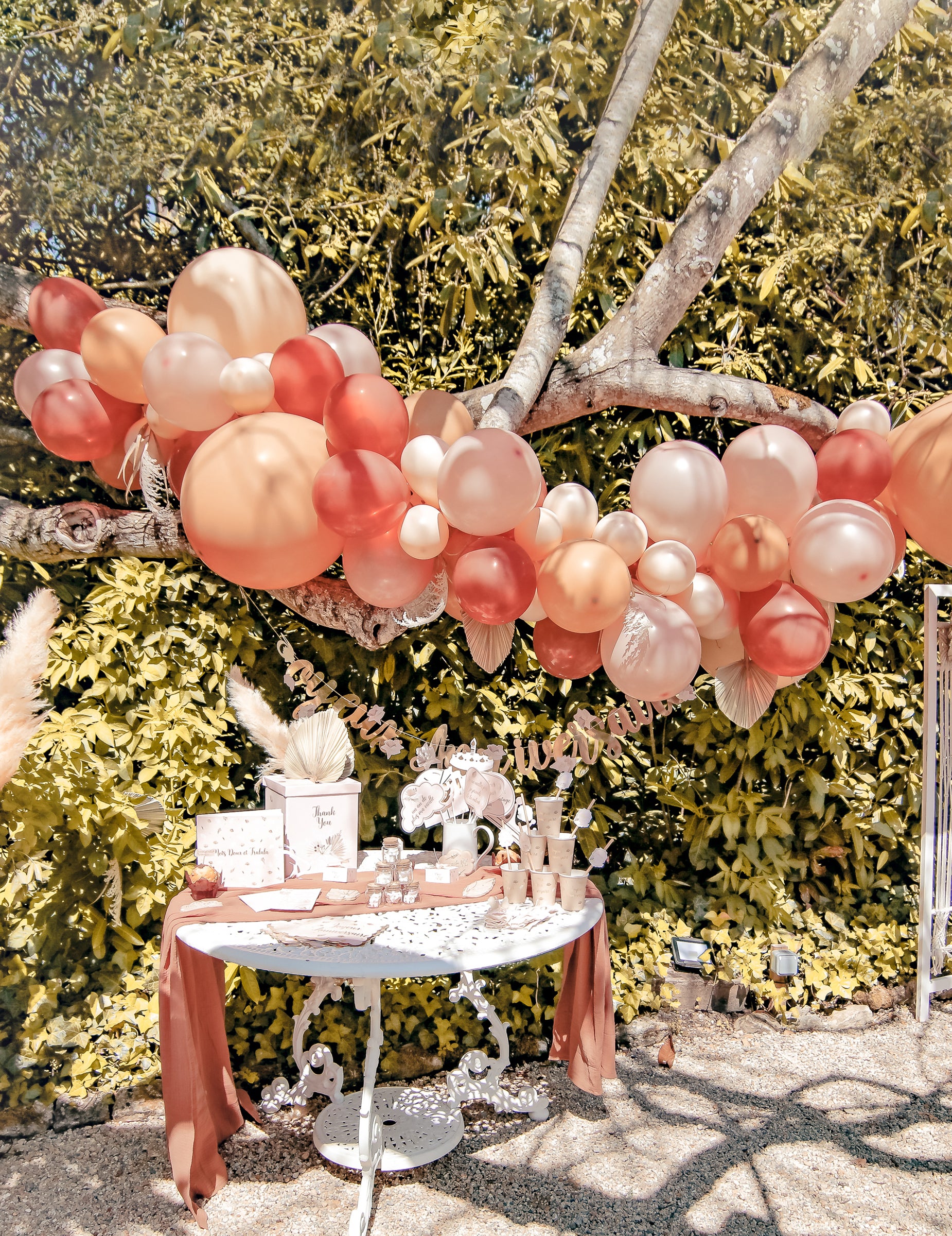 Mise en situation en extérieur du kit arche de 70 ballons boho avec pampa et feuilles séchées